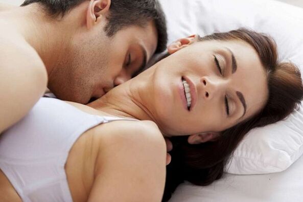 Hombres y mujeres emocionados en la cama